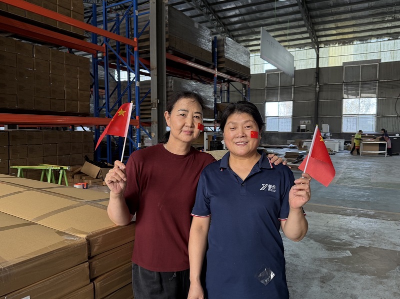 Team members celebrate among packed goods and materials.